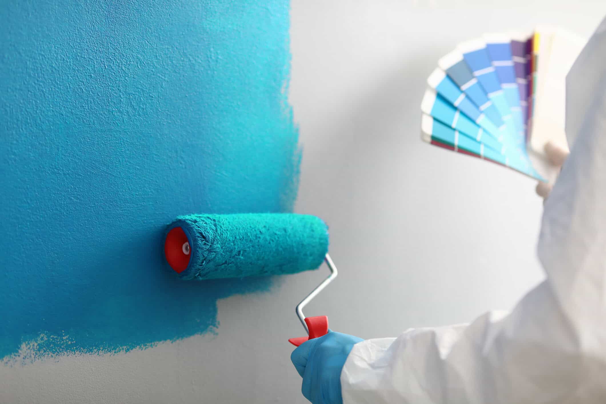 Master painter holds in his hands color palette with shades of blue how to paint textured walls
