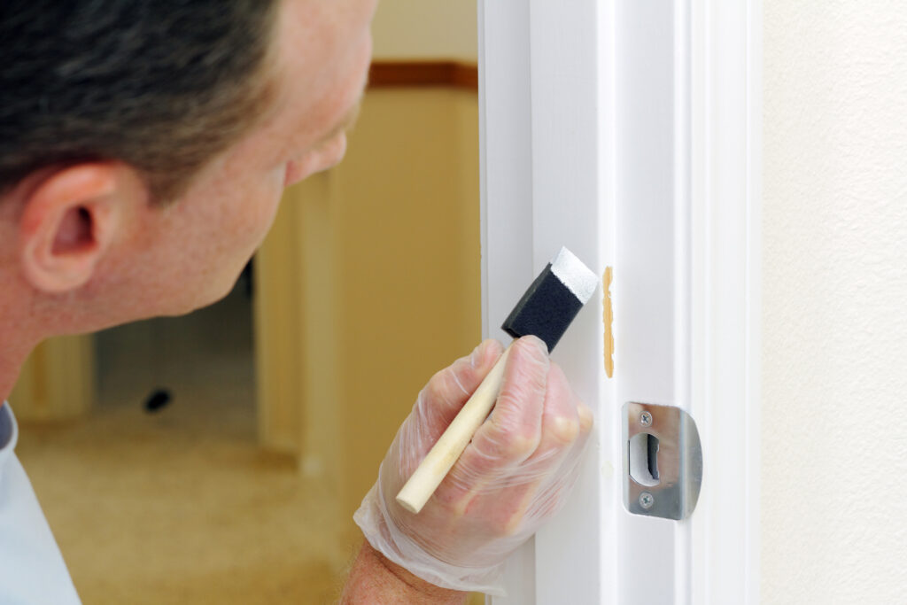 Interior Residential Wall Painting Painter applying finish to an interior door frame